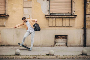 Man skateboarding on a city sidewalk.