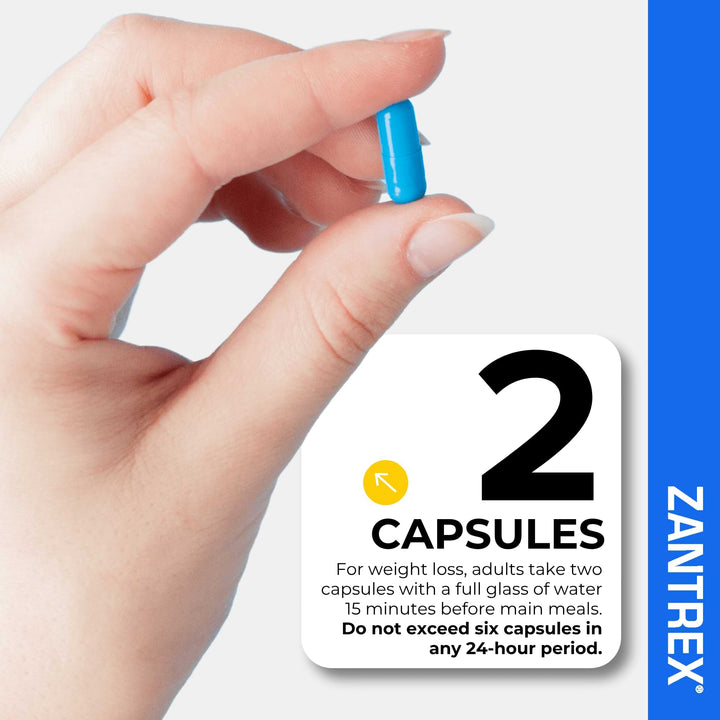 Hand holding a blue capsule with Zantrex label and capsule information.